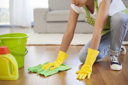 Cleaner removing stains from a sofa during upholstery service
